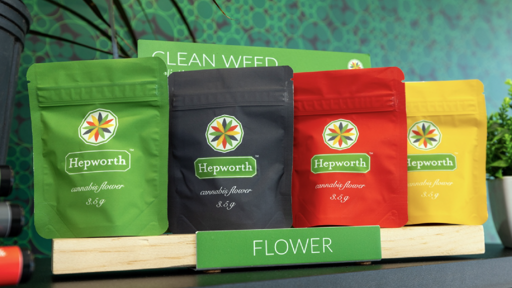 Colorful cannabis flower bags from Hepworth, a well-known cultivator in New York, displayed on a wooden shelf at The Plant dispensary.